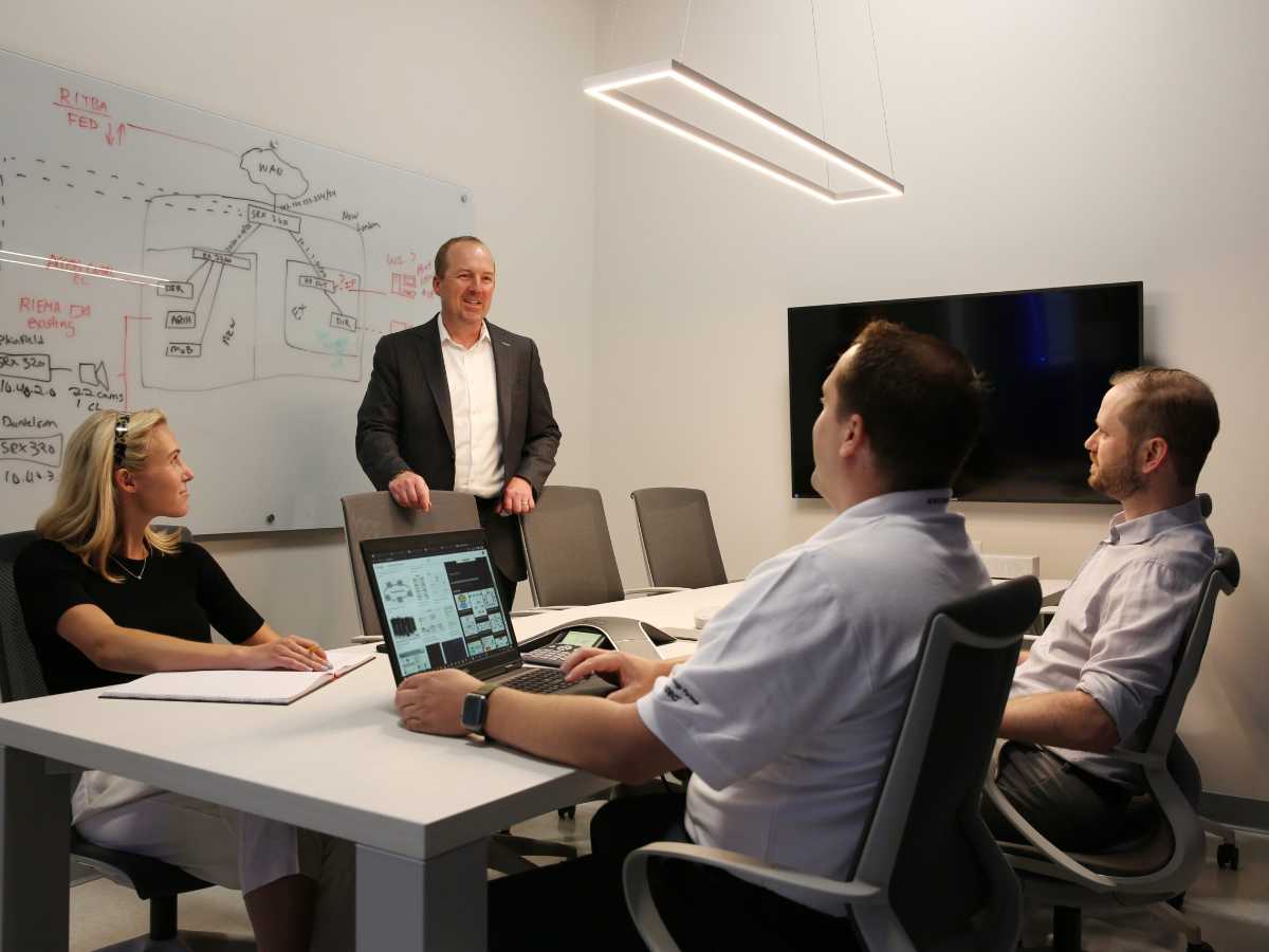 Four employees in conference room collaborating