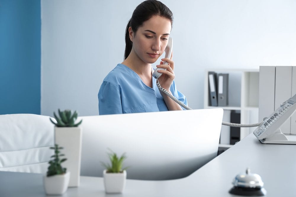 nurse on the phone in a hospital wearing scrubs