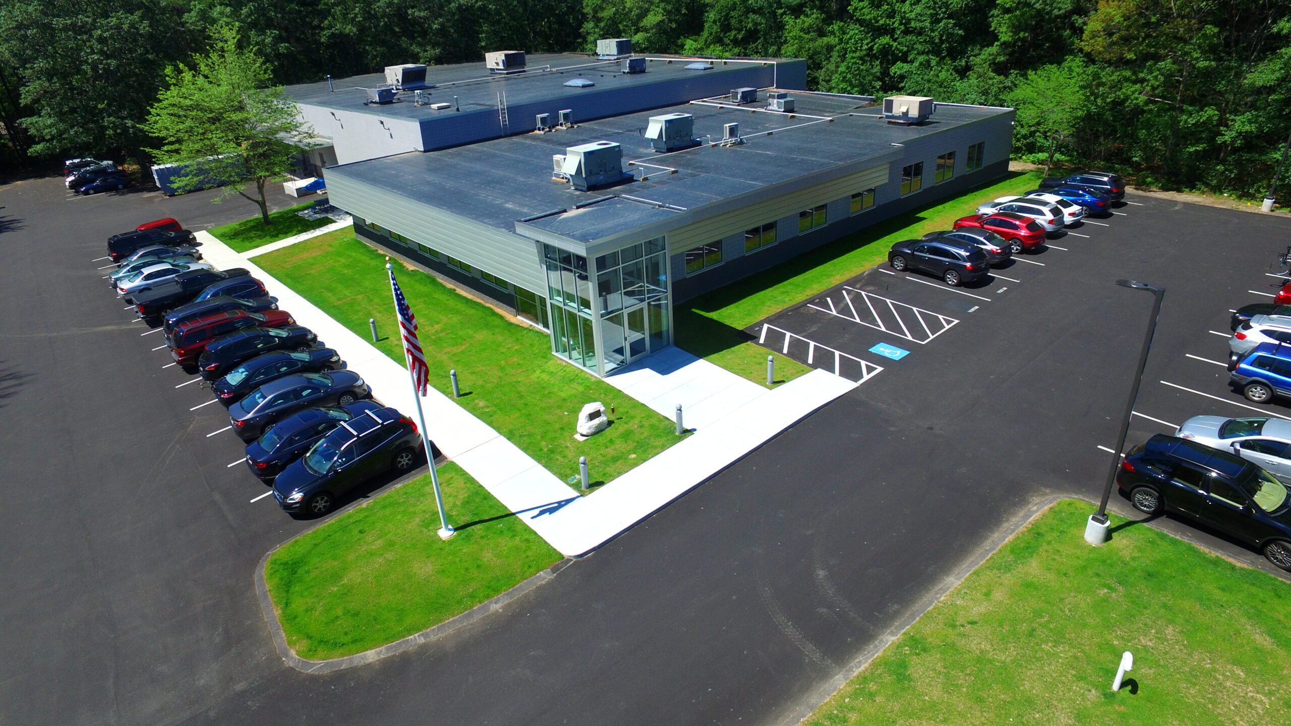 “Company headquarters aerial shot with cars in the parking lot”