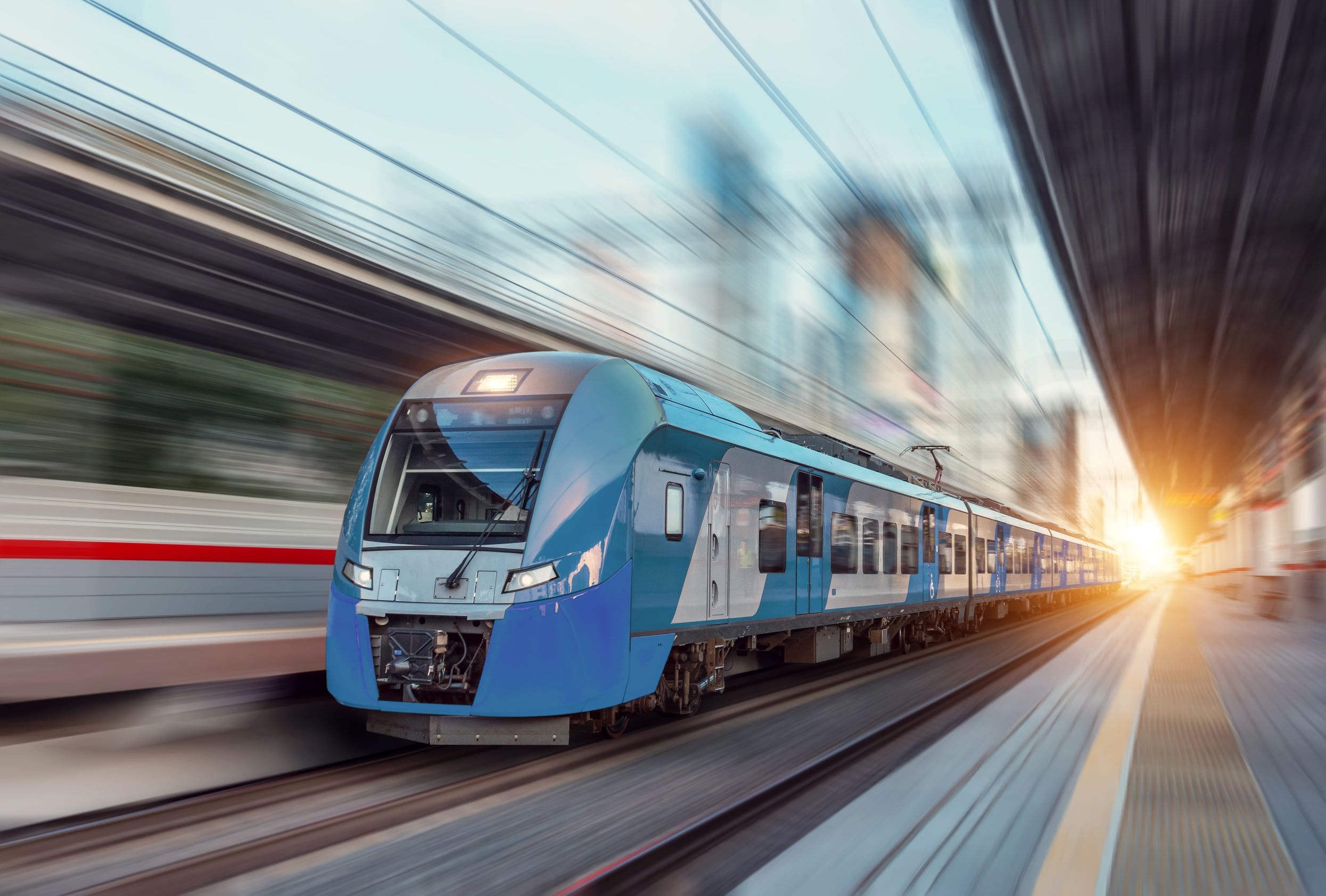 Train leaving a station quickly at sunset