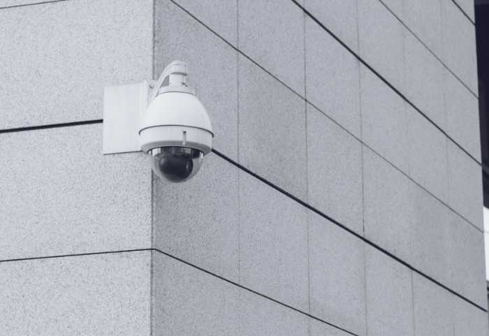 white security camera on a building in a city